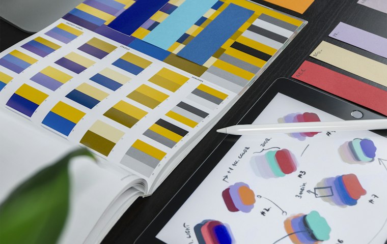 Brand colour swatches and print samples on a desk